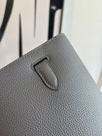 Hermes leather flap bag detail, textured gray flap tab with curved top stitch