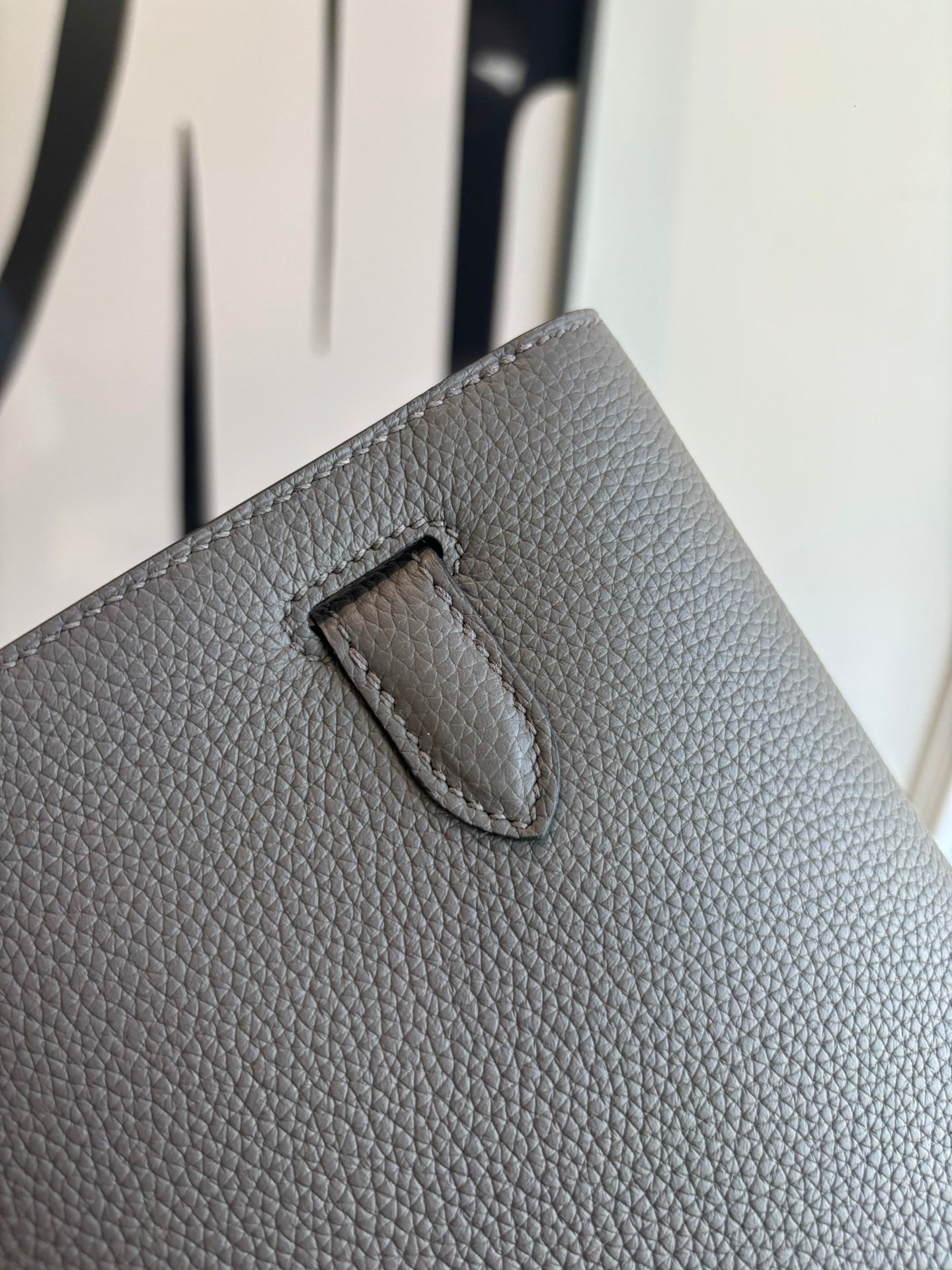 Hermes leather flap bag detail, textured gray flap tab with curved top stitch