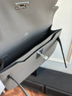 Hermes leather flap bag open, gray interior lining and silver lock clasp