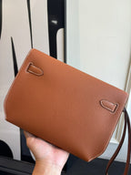 Hermes brown leather flap bag with stitched flap and decorative corner loops
