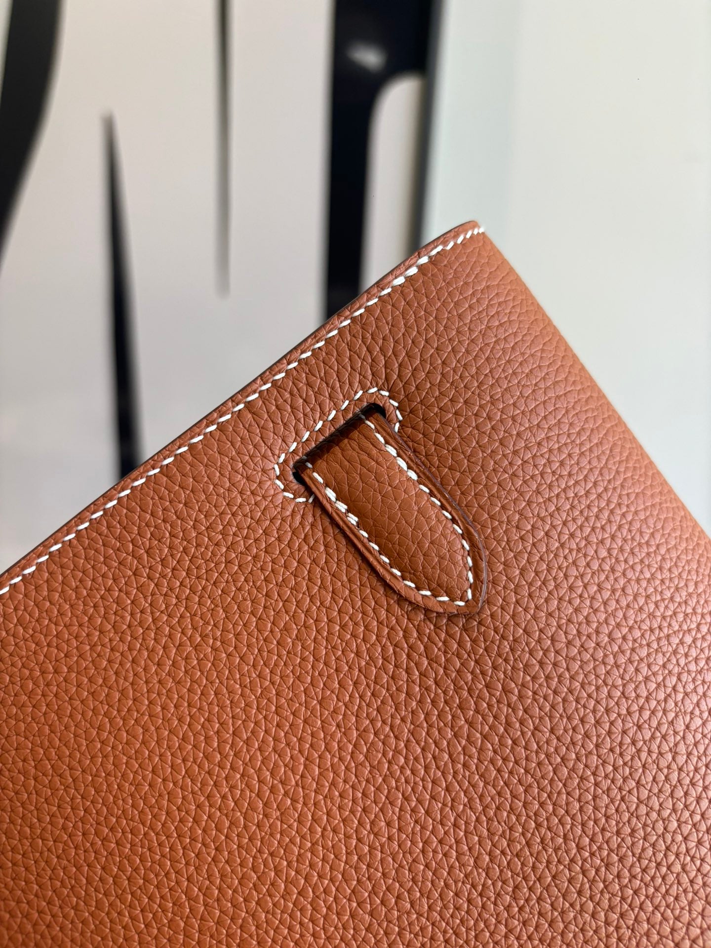Hermes brown leather flap bag latch with stitched leather handle detail