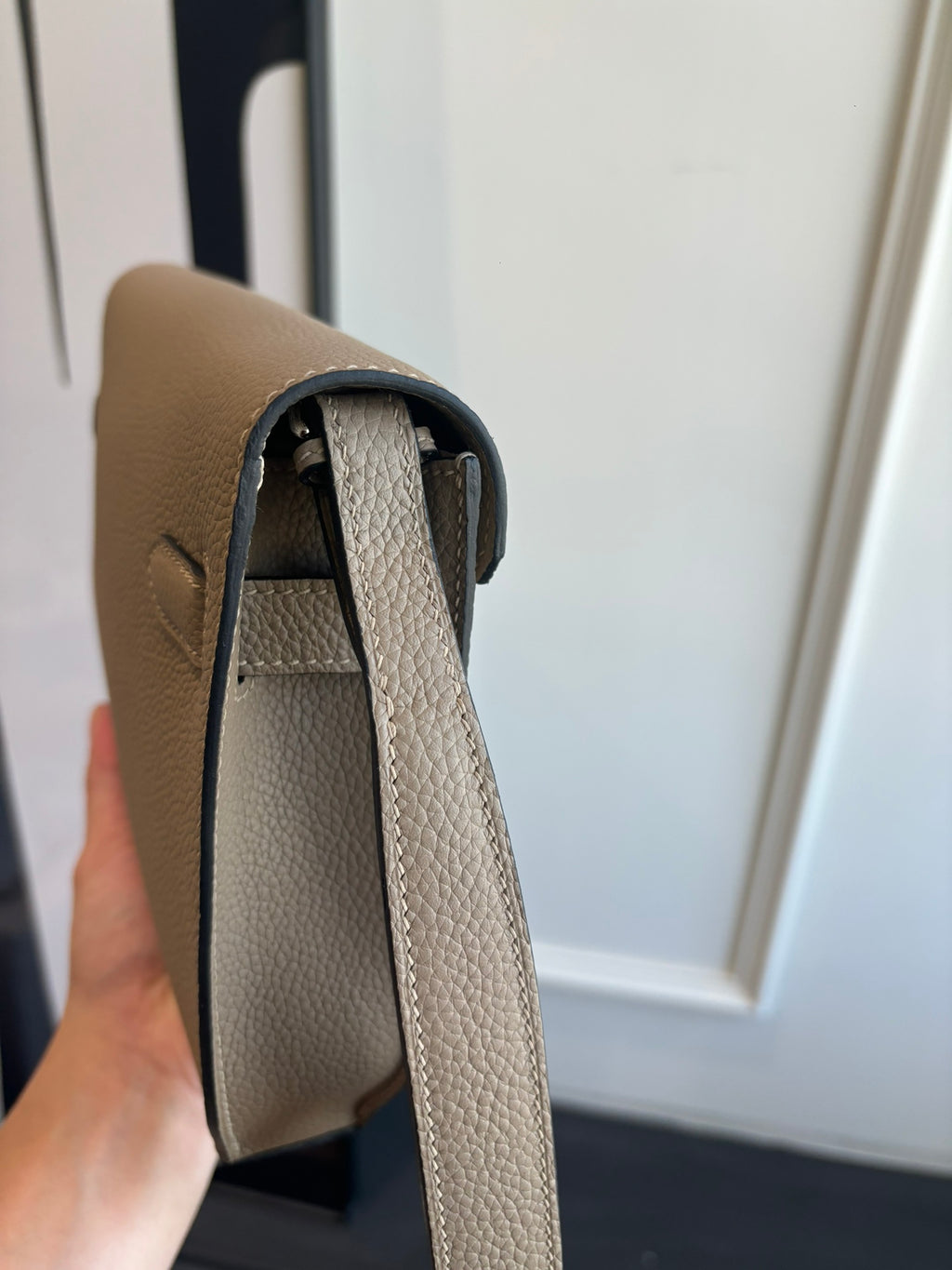 Hermes taupe leather bag side view with top opening and interior lining visible
