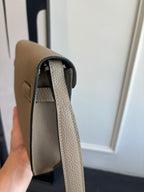 Hermes taupe leather bag side view with top opening and interior lining visible