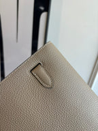 Hermes bag exterior close-up with stitched front tab on textured taupe leather