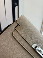 Hermes flap shoulder bag close-up with front tab and silver-tone belt buckle detail