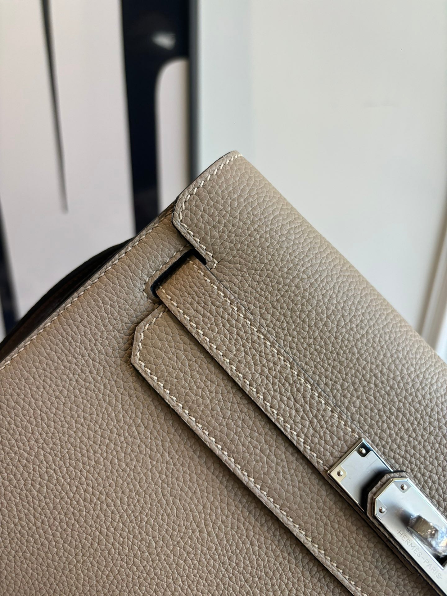 Hermes flap shoulder bag close-up with front tab and silver-tone belt buckle detail