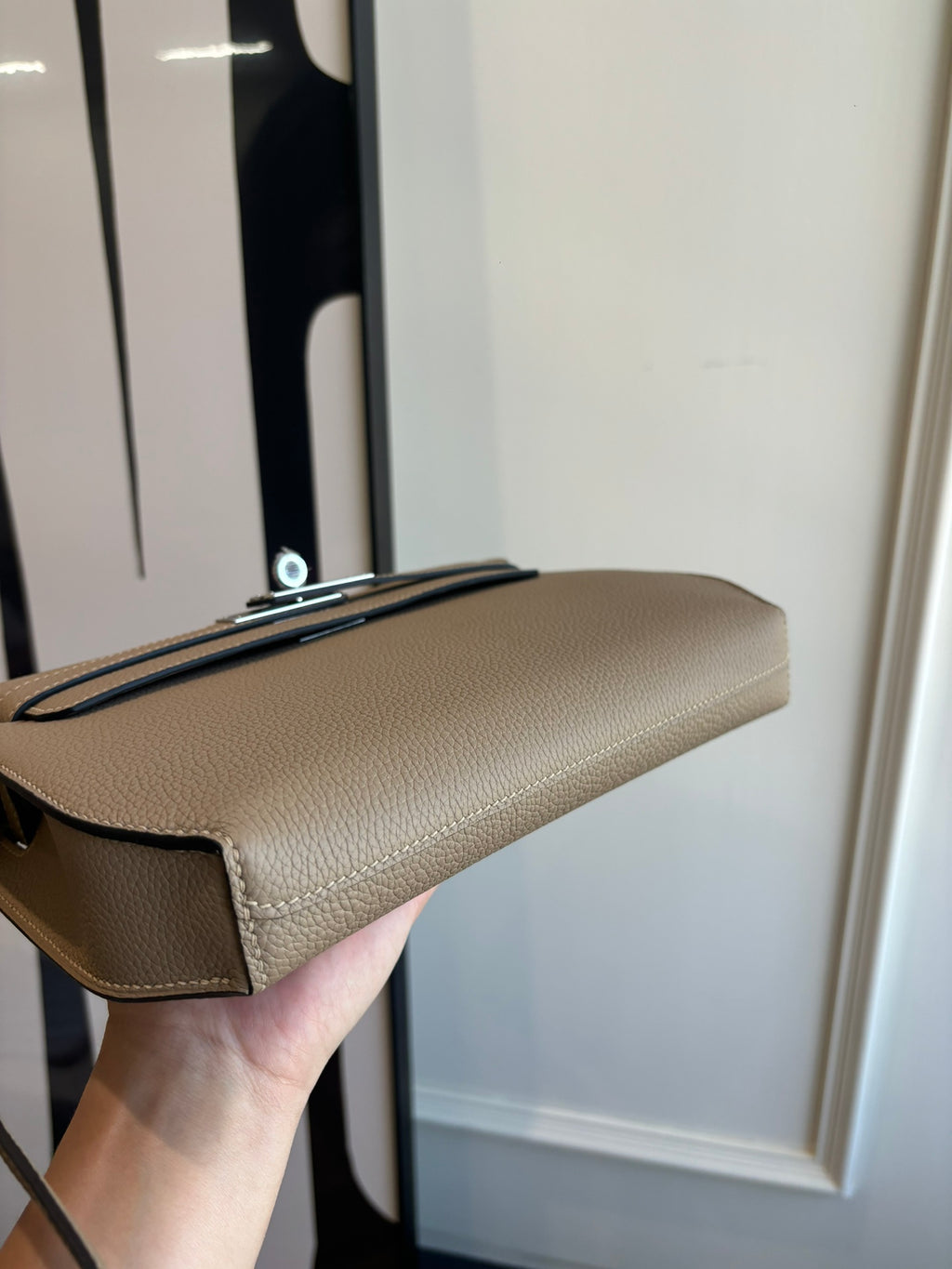 Hermes flap shoulder bag angled view with top edge, stitched seams, and strap