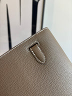 Hermes leather bag buckle detail, taupe pebbled texture and stitched strap tab