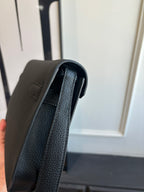 Hermes leather bag edge view showing interior lining, textured dark grain, shoulder strap