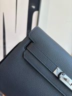 Hermès small shoulder bag close-up, textured dark leather with gold hardware