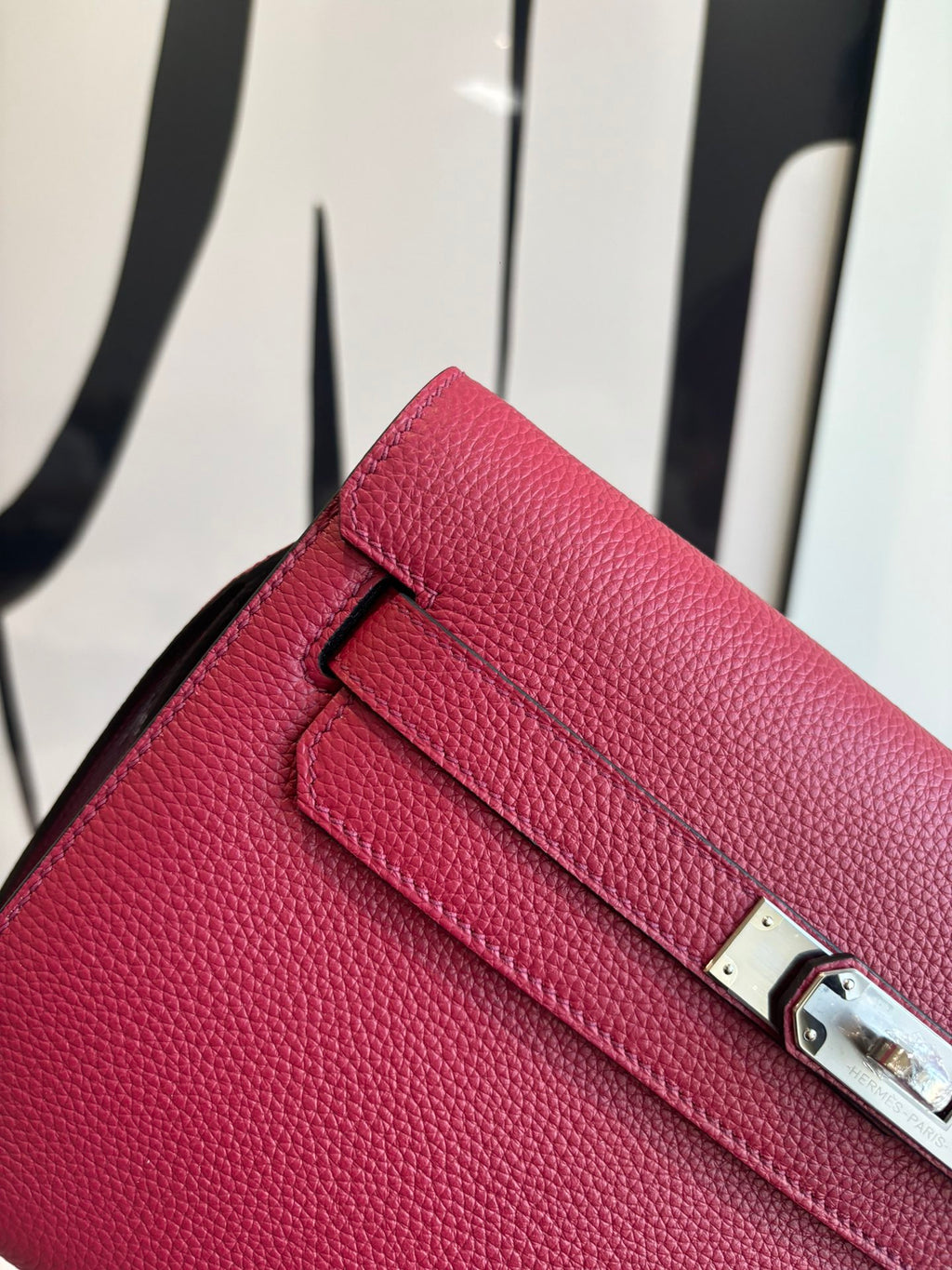 Hermes bag close-up of textured leather flap with silver hardware and latch.