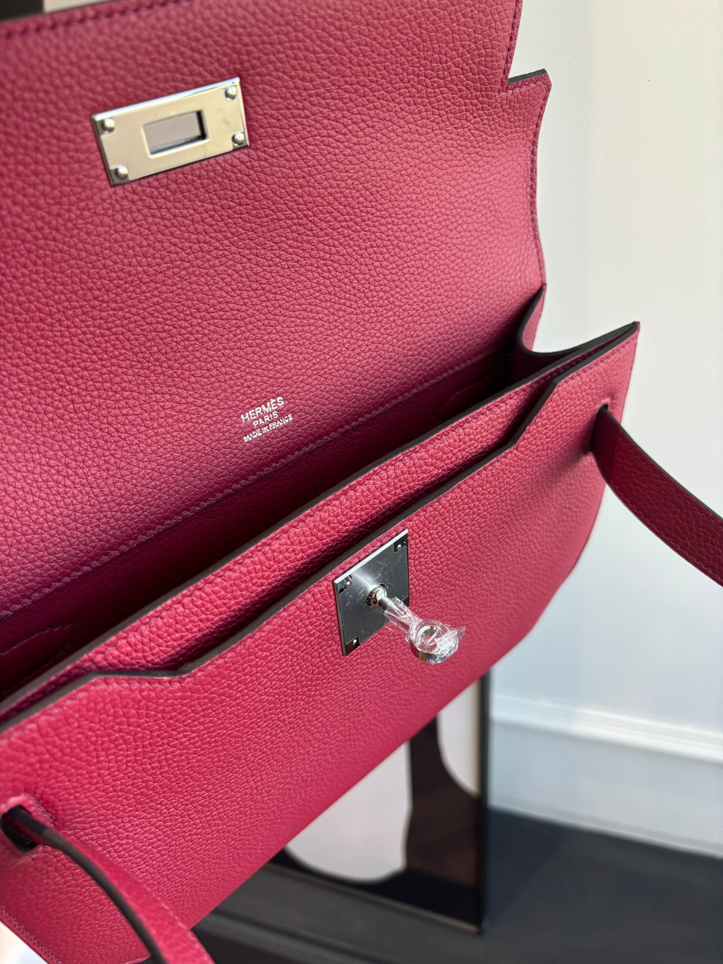 Hermes bag hardware close-up with silver turn-lock and adjustable strap attachment.