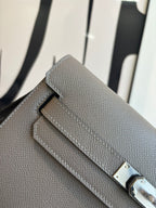 Gray pebbled leather clutch bag close-up of front flap and metal clasp