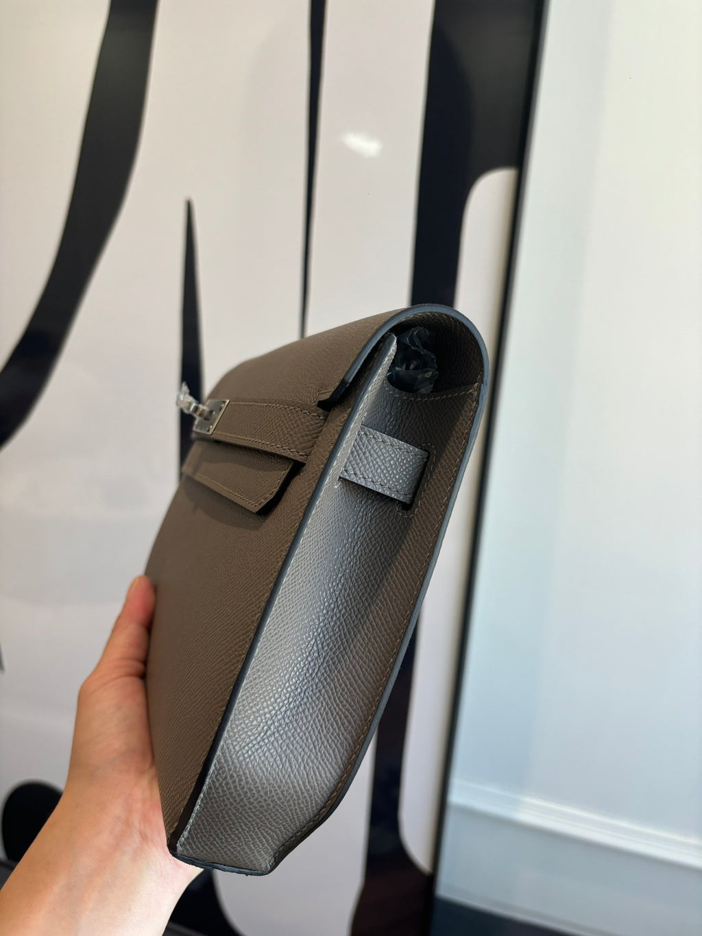 Gray leather clutch bag with short shoulder strap and front flap
