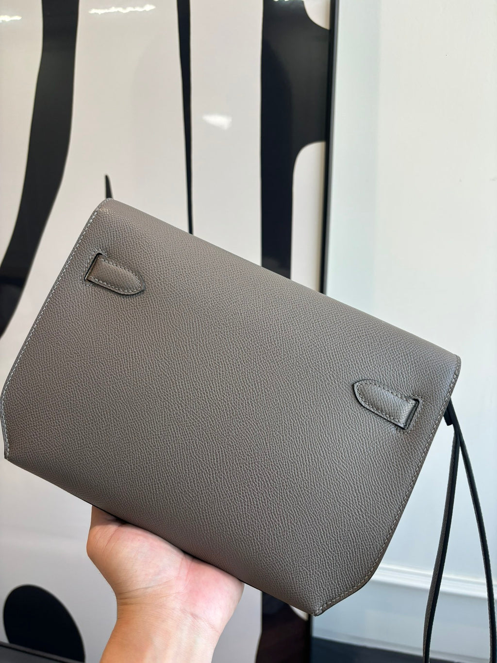 Gray pebbled leather clutch bag with top flap and small corner accents