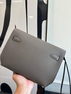 Gray pebbled leather clutch bag with top flap and small corner accents
