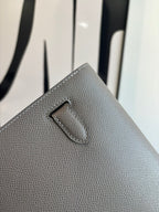 Gray pebbled leather clutch bag front flap with stitched center tab detail