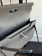 Gray pebbled leather clutch bag with hinged front clasp and inner opening