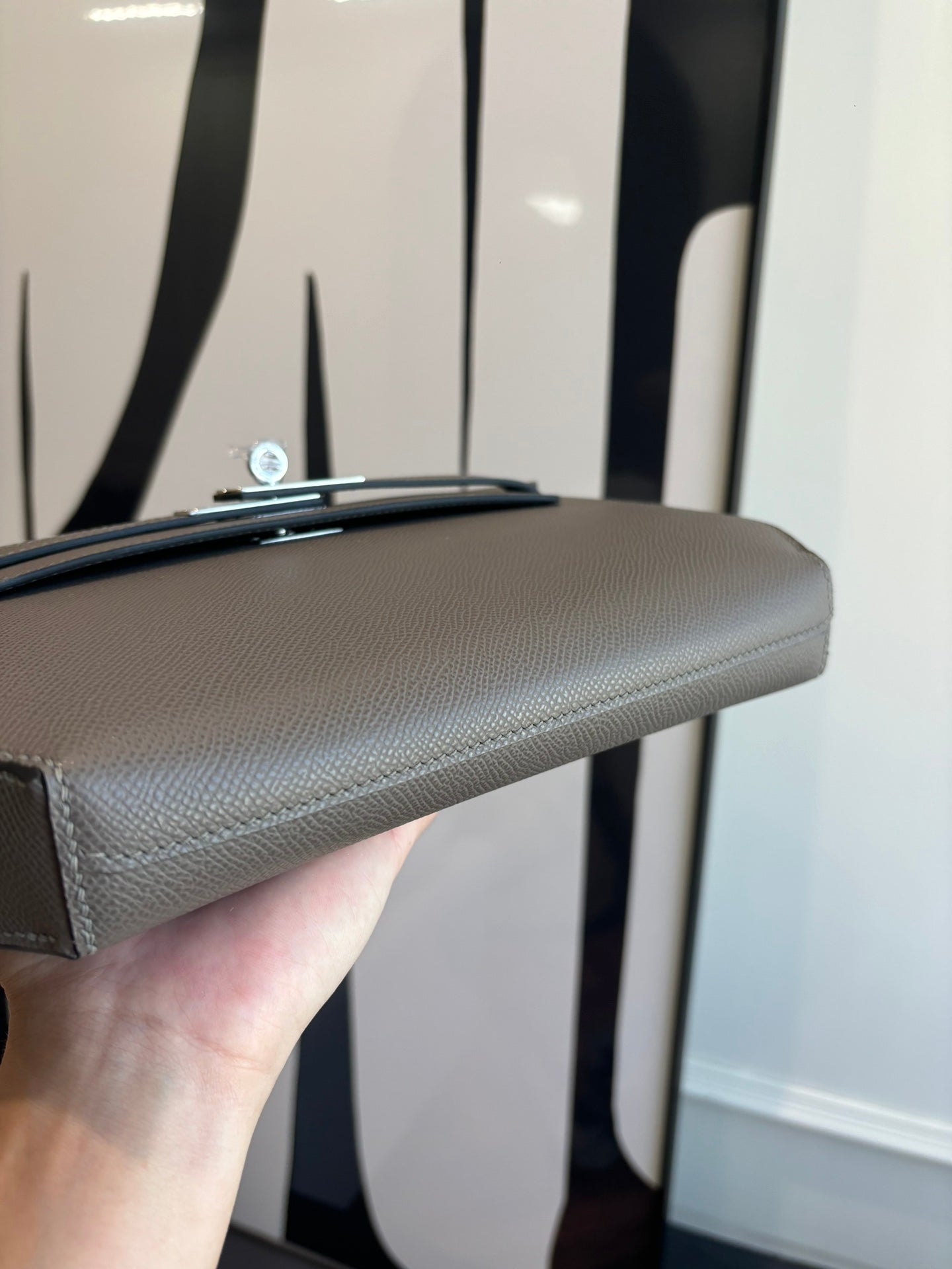 Gray pebbled leather clutch bag side view with turn-lock hardware