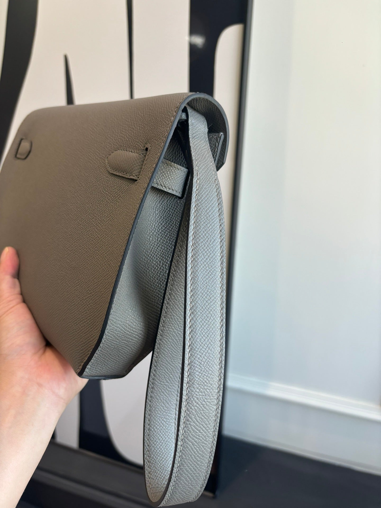 Hermes bag open side with curved top opening and light blue-gray leather lining