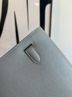 Hermes bag close-up of front flap tab on light blue-gray textured leather