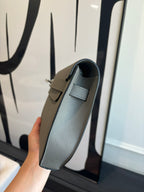 Hermes bag side view with top handle, light blue-gray leather and fold-over flap
