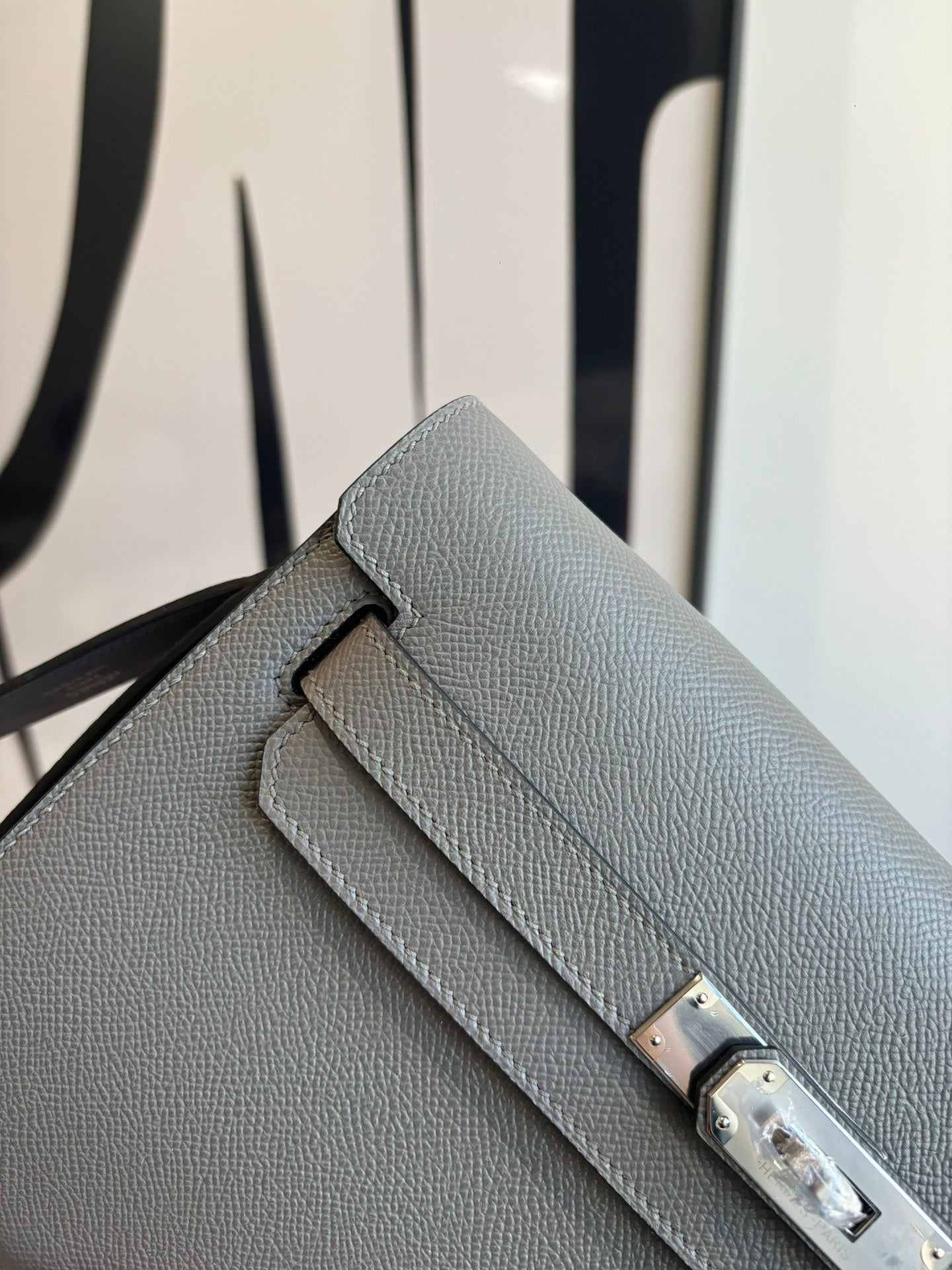 Hermes bag front, textured leather with double stitched flap and gold-tone clasp