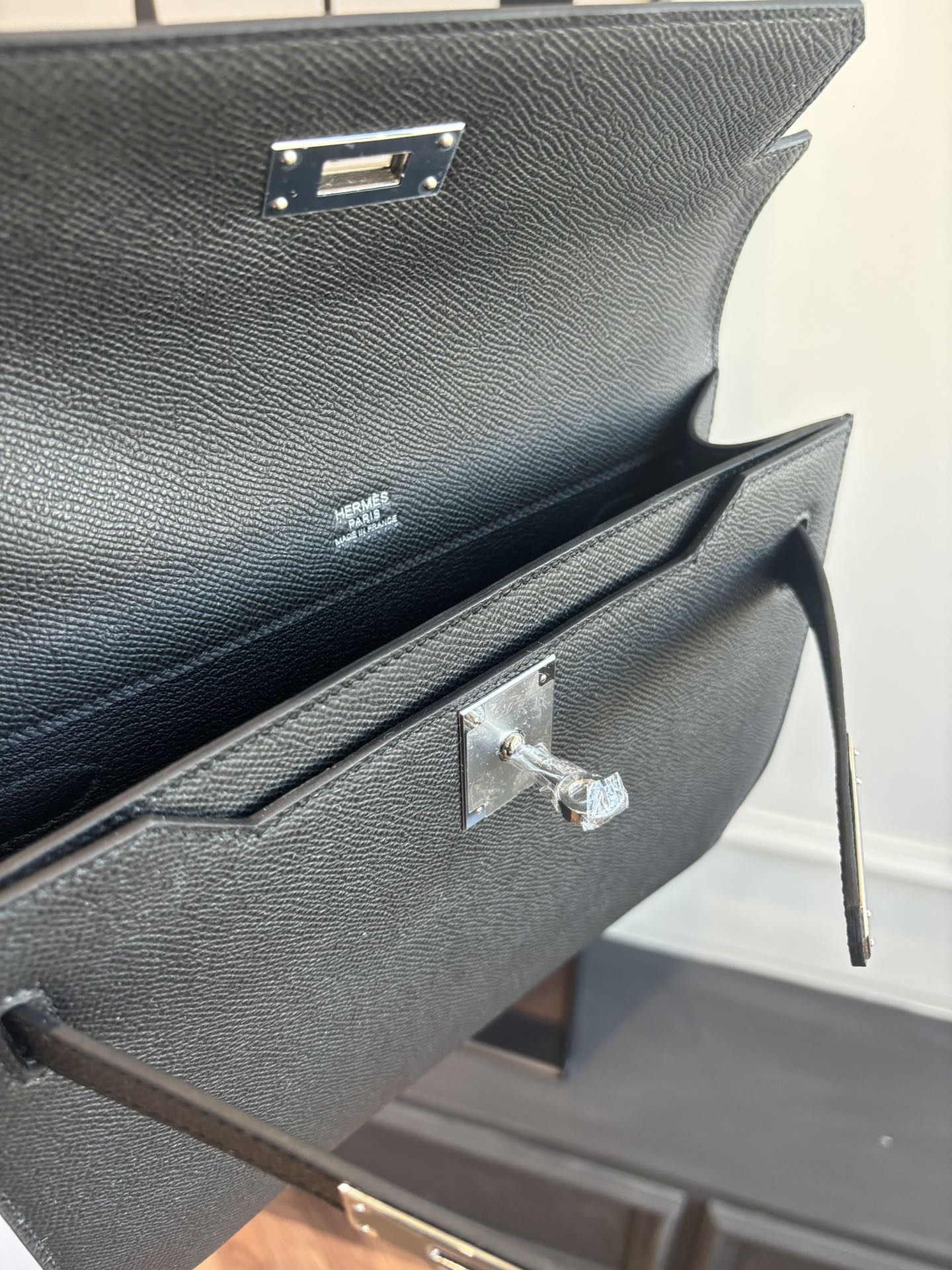 Flap bag interior top hinge and silver bar clasp detail on textured dark blue leather