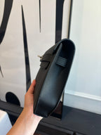Flap bag side view with adjustable strap and structured textured body, dark blue