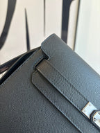 Flap bag close-up: textured leather and silver turn-lock detail on dark blue front