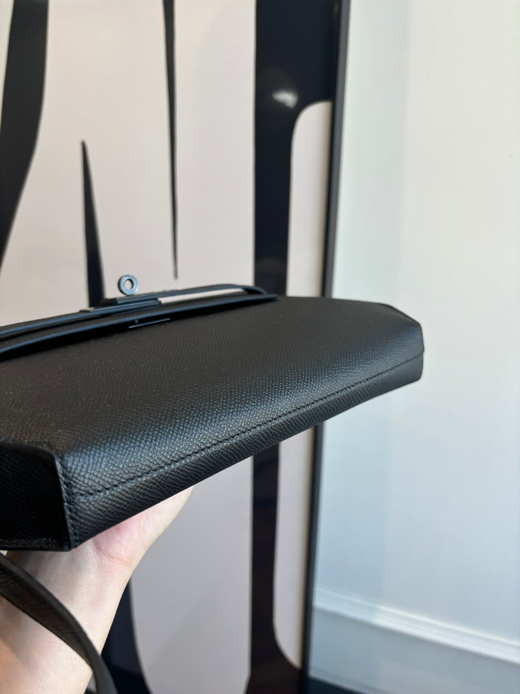 Hermes bag top edge view with smooth textured dark leather and handle attachment