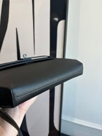 Hermes bag top edge view with smooth textured dark leather and handle attachment