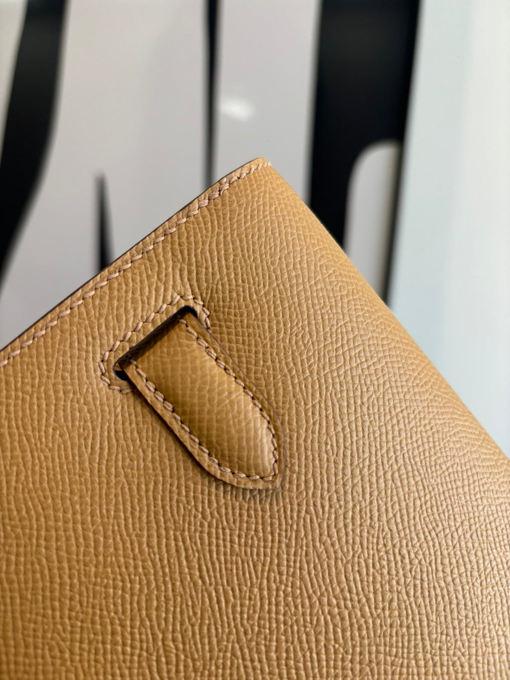 Hermes tan leather flap bag corner with stitched strap detail