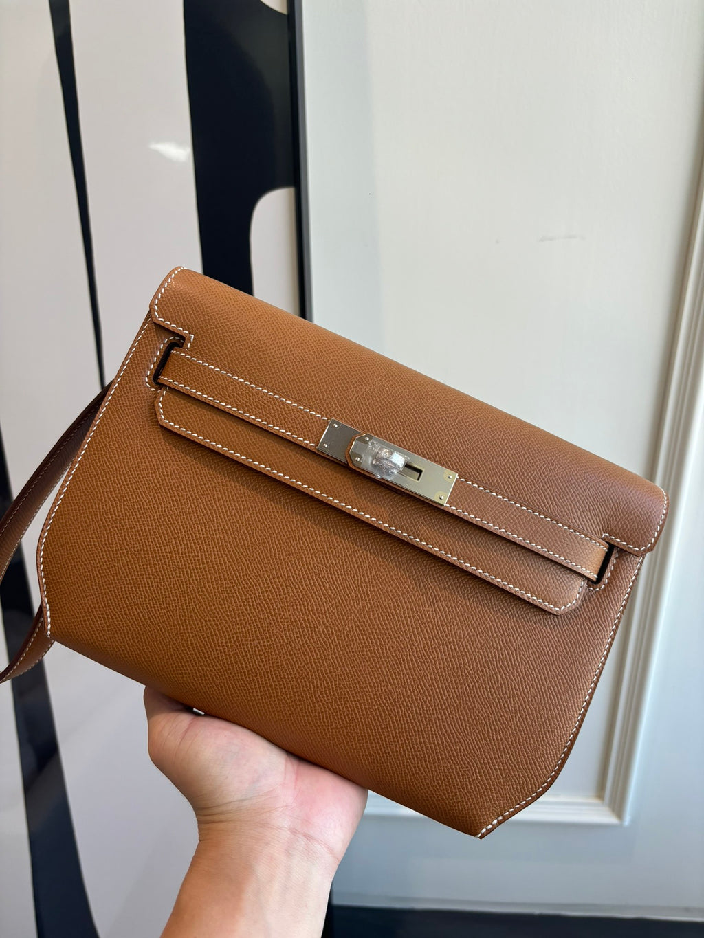 Hermes brown leather flap bag with front buckle clasp and contrast stitching
