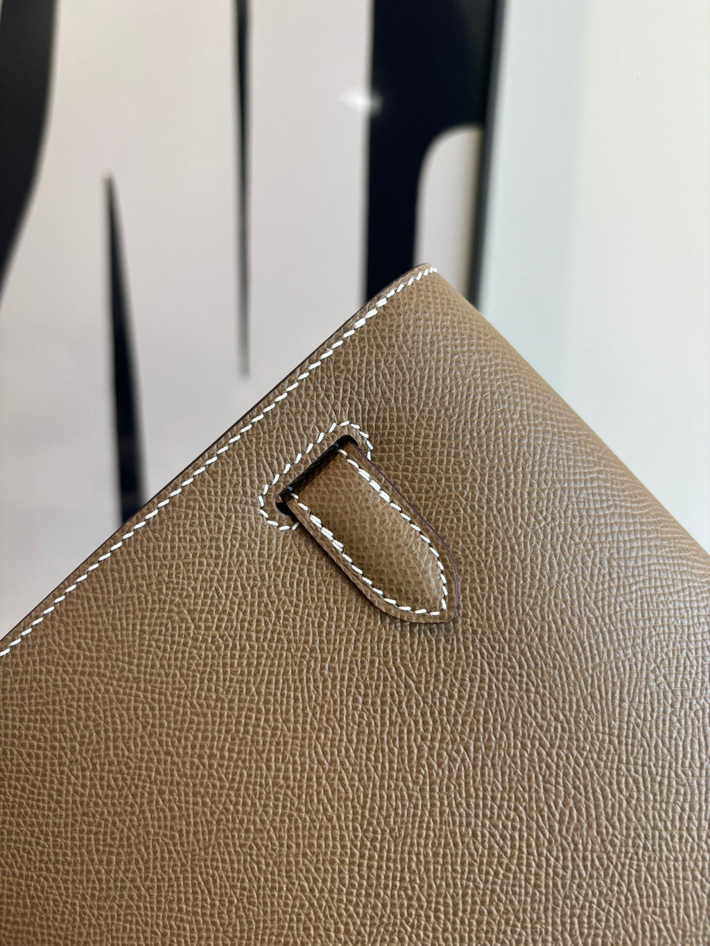 Hermes flap shoulder bag corner detail with engraved buckle and stitched edge