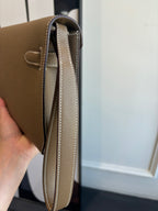 Hermes flap shoulder bag side view showing strap and light interior lining