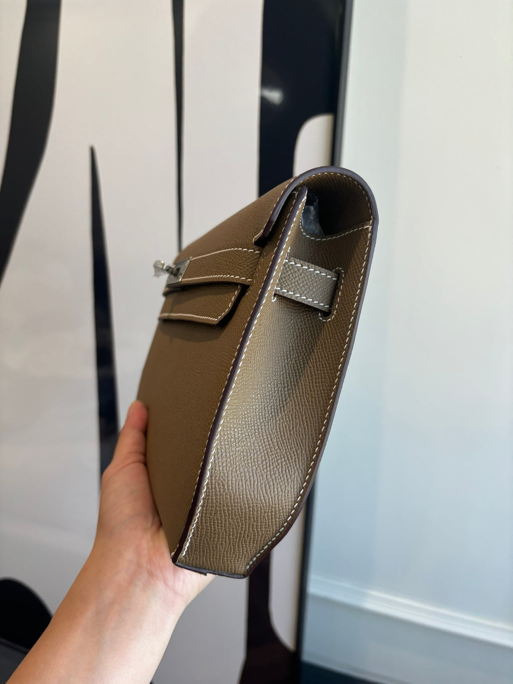 Hermes flap shoulder bag side view with brown leather and adjustable strap