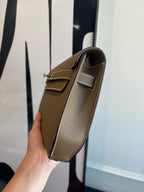 Hermes flap shoulder bag side view with brown leather and adjustable strap