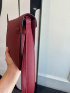 Red leather bag interior opening with strap and lined inside, side view