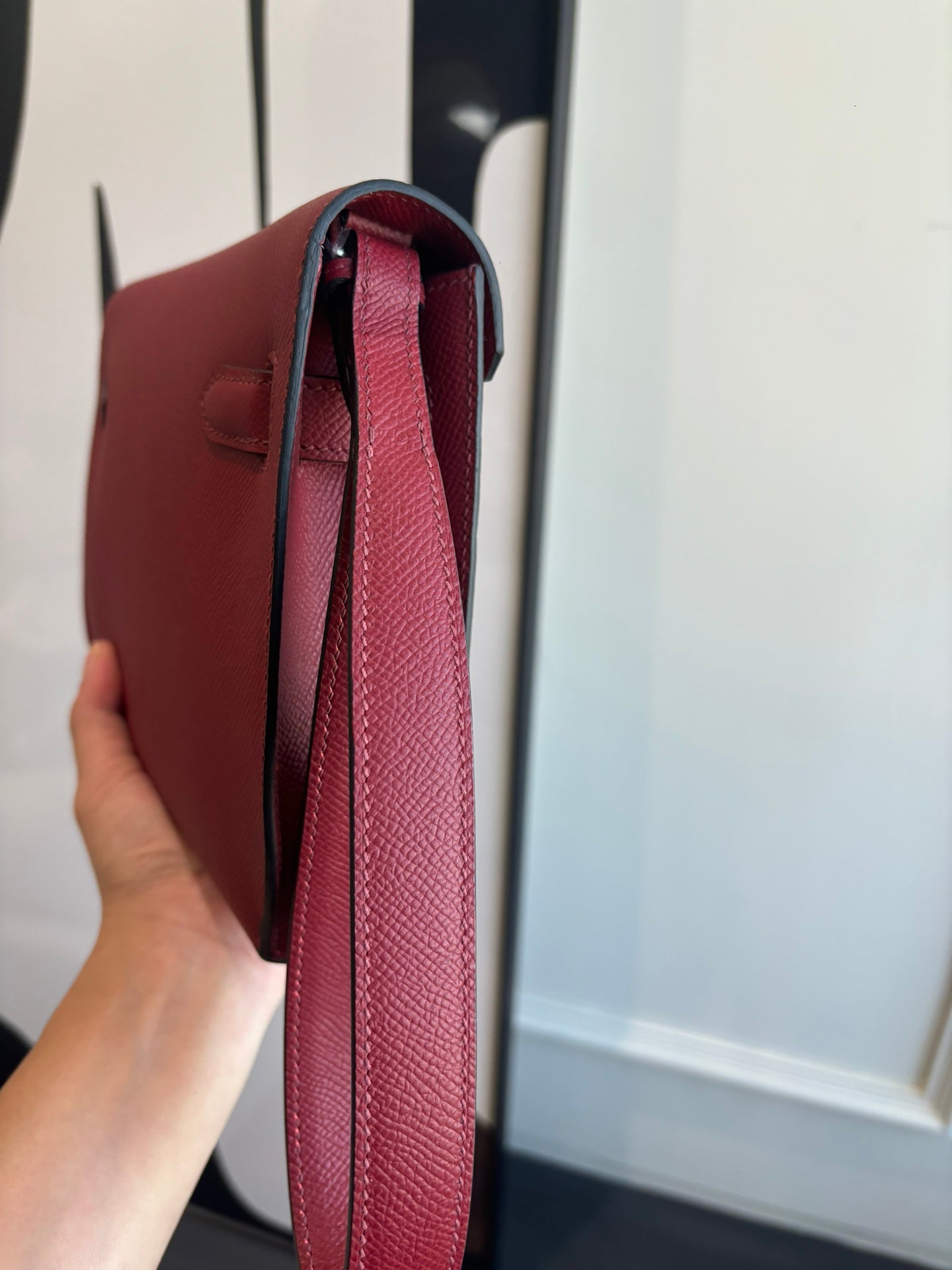 Red leather bag interior opening with strap and lined inside, side view