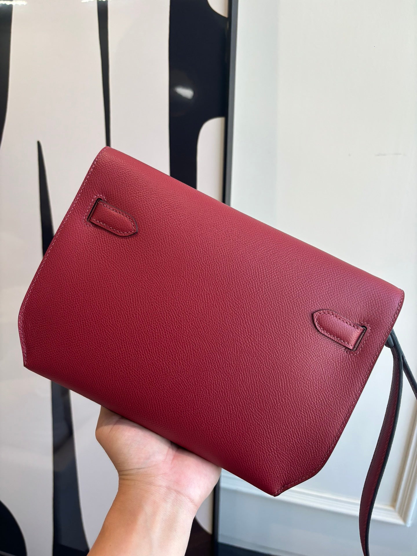 Red leather shoulder bag with curved flap and small corner flap tabs