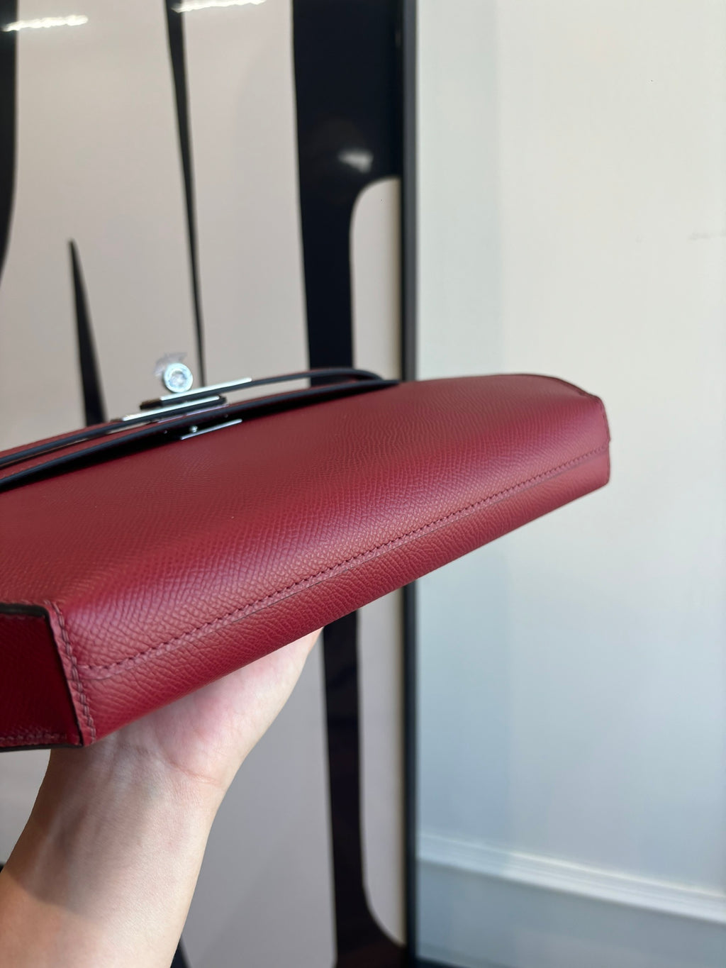 Red leather shoulder bag top edge with silver-tone clasp hardware