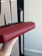 Red leather shoulder bag top edge with silver-tone clasp hardware