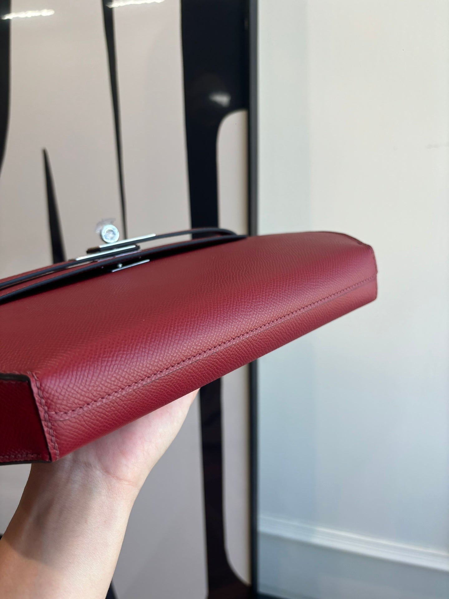 Red leather shoulder bag top edge with silver-tone clasp hardware
