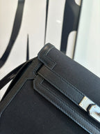 Hermes bag close-up of front flap, stitched edging, and rectangular gold-tone hardware