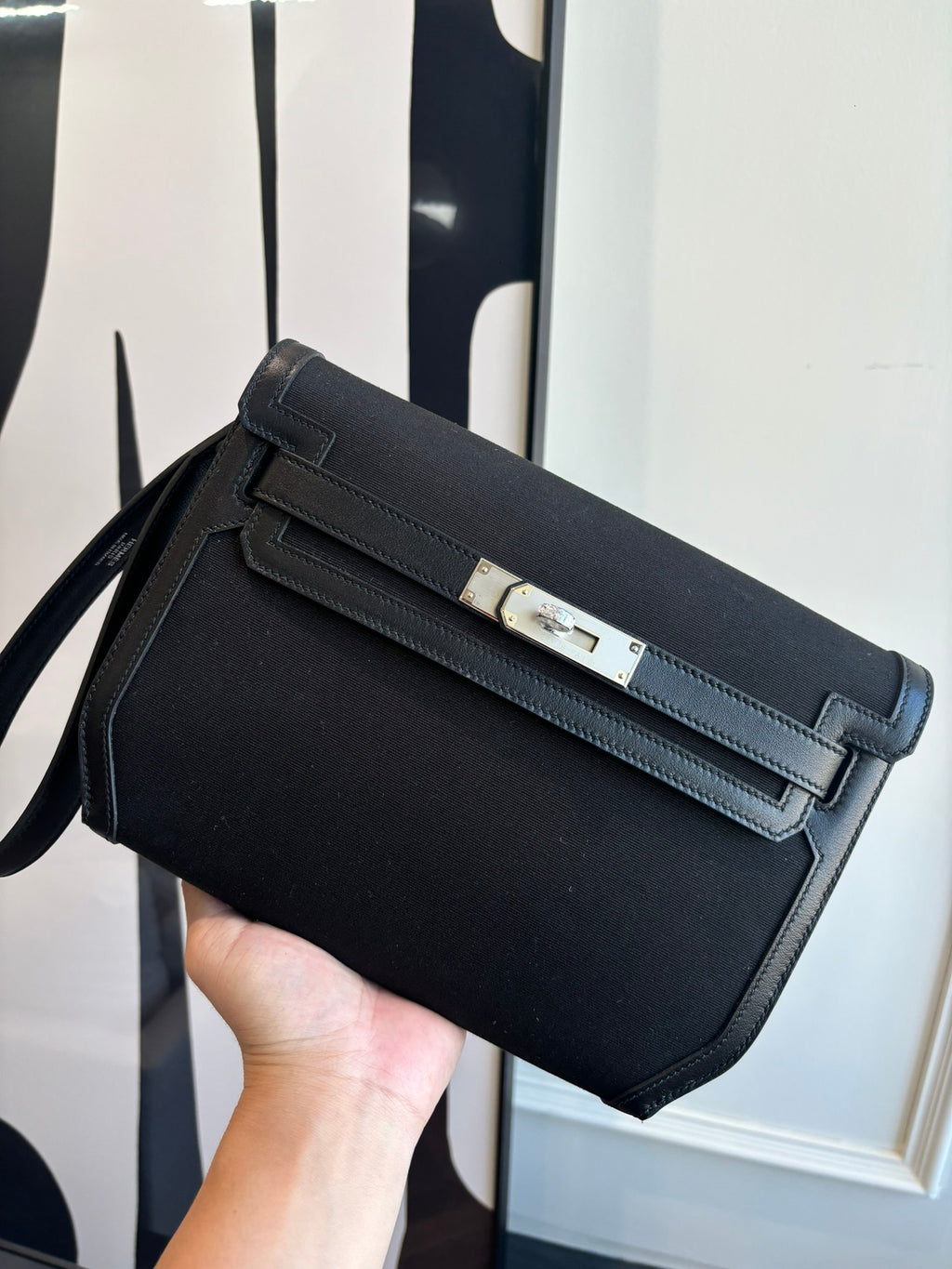 Hermes shoulder bag with top flap, front belt strap, and gold-tone clasp hardware