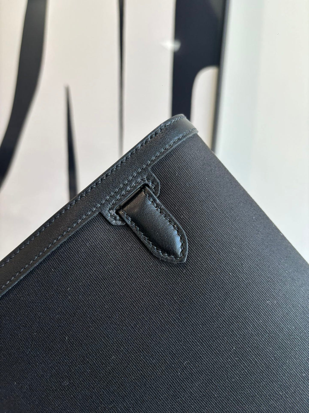 Hermes bag corner with stitched flap tab and secure closure detail