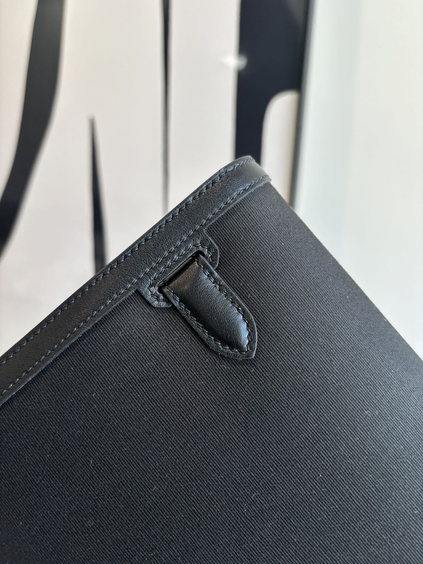 Hermes bag corner with stitched flap tab and secure closure detail