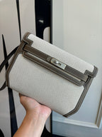 Beige textured Hermes bag with brown leather trim and top flap closure