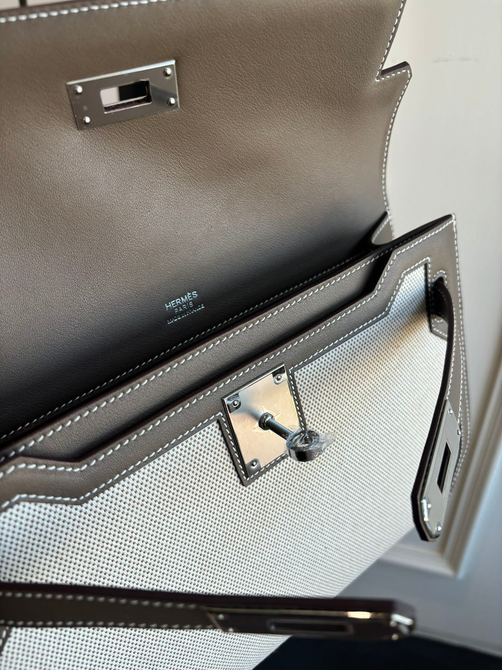 Close-up of Hermes bag interior with toggle clasp, stitching, and logo panel
